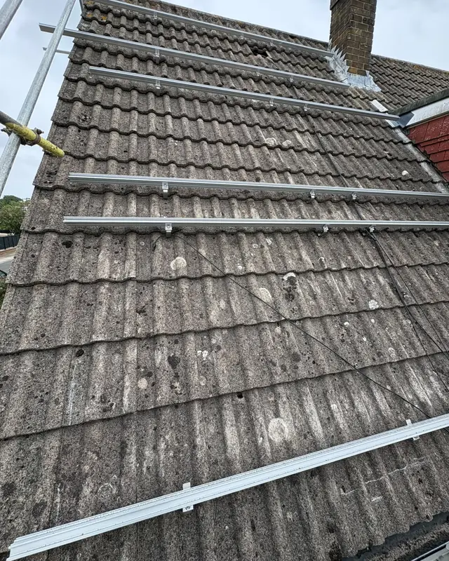 The same roof with aluminium mounting rails fixed across the tiles, ready for the panels